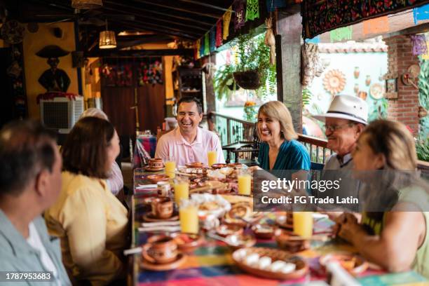 amici anziani felici che parlano al ristorante - mexican food foto e immagini stock