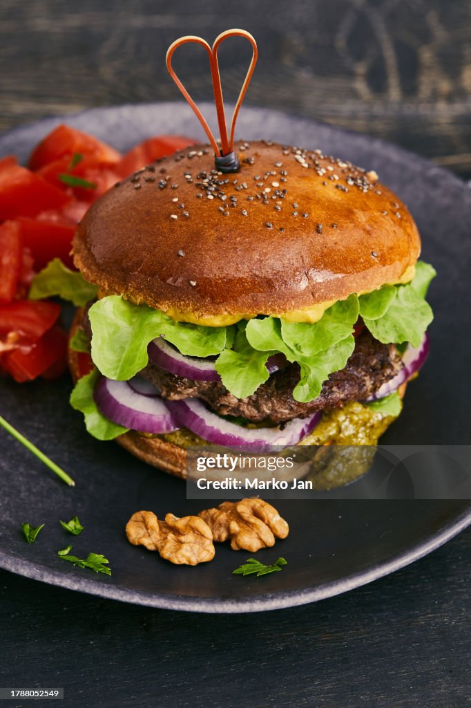 Luxury tasty & juicy beef burger on a dark plate. Gourmet Burger Happiness