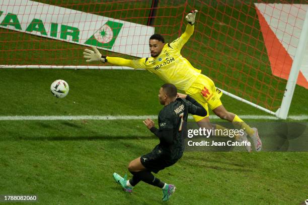 Kylian Mbappe of PSG scores his third goal against Reims goalkeeper Yehvann Diouf during the Ligue 1 Uber Eats match between Stade de Reims and Paris...