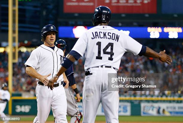 Andy Dirks of the Detroit Tigers celebrates scoring a third inning run with Austin Jackson while playing the Cleveland Indians at Comerica Park on...