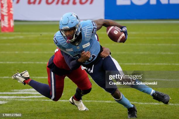 Javon Leake of the Toronto Argonauts tries to break a tackle from Tyrell Richards of the Montreal Alouettes on a kick return during the first half of...