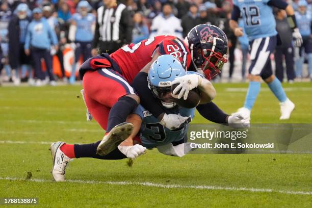 Tyrice Beverette of the Montreal Alouettes tackles AJ Ouellette of the Toronto Argonauts on a rushing play during the first half of the CFL Eastern...