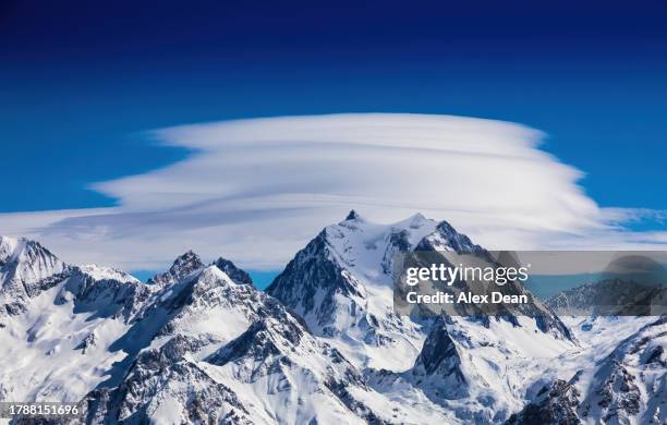 lenticular cloud over a mountain. - meribel stock pictures, royalty-free photos & images