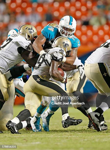 Francis of the Miami Dolphins tackles Khiry Robinson of the New Orleans Saints during a preseason game on August 29, 2013 at Sun Life Stadium in...