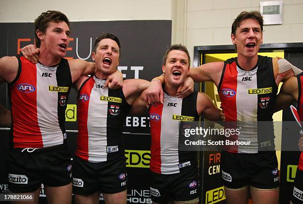 Justin Koschitzke, Stephen Milne and Adam Schneider of the Saints sing the team song in the changing rooms after winning the round 23 AFL match...