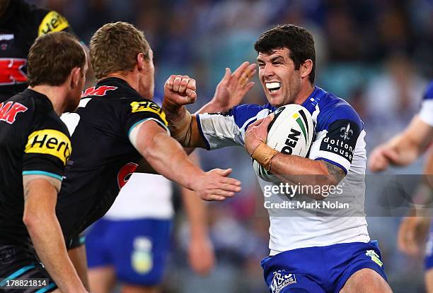 Michael Ennis of the Bulldogs takes on the Panthers defence during the round 25 NRL match between the Canterbury Bulldogs and the Penrith Panthers at...