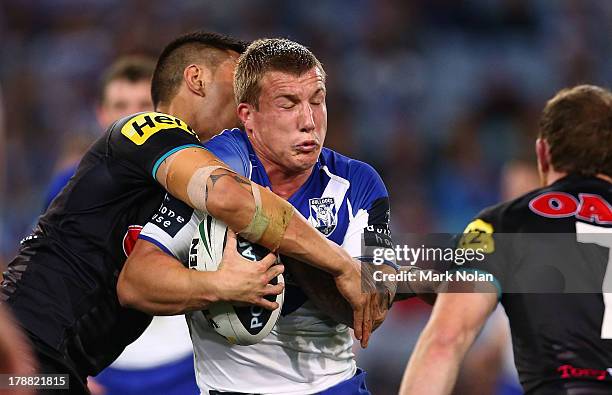Michael Hodkinson of the Bulldogs is tackled during the round 25 NRL match between the Canterbury Bulldogs and the Penrith Panthers at ANZ Stadium on...