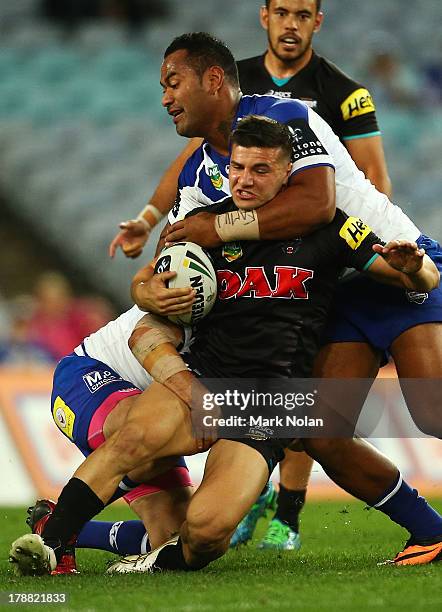 Josh Mansour of the Panthers is tacked high by Tony Williams of the Bulldogs during the round 25 NRL match between the Canterbury Bulldogs and the...