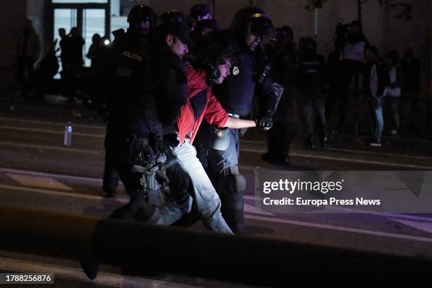 Demonstrator is detained by two police officers during a protest against the amnesty in front of the PSOE headquarters on November 11 in Madrid,...