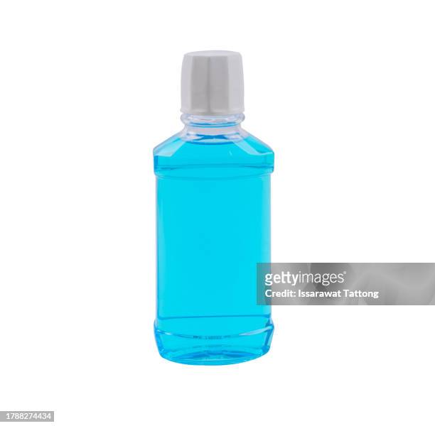 mouthwash bottle for oral hygiene routine on light blue background. mouth rinse liquids help to against bad breath, cavities and plaque. dental care product - minze freisteller stock-fotos und bilder