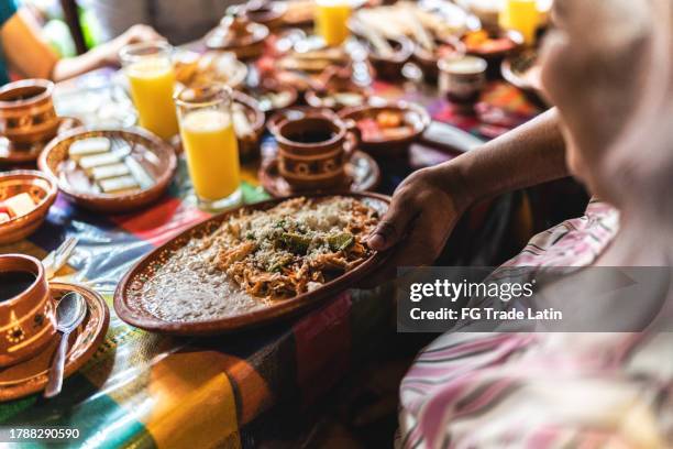 primer plano de un camarero sirviendo comida mexicana a un cliente en el restaurante - chilaquiles fotografías e imágenes de stock