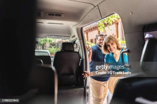 senior tourist woman getting into a tour van - bus-door stock pictures, royalty-free photos & images