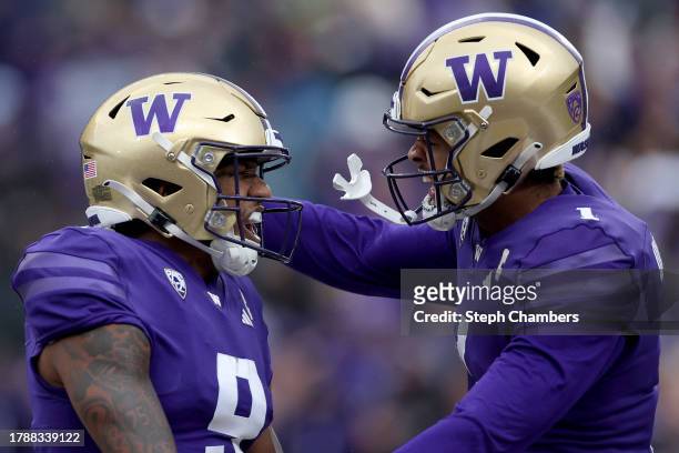 Michael Penix Jr. #9 and Rome Odunze of the Washington Huskies celebrate their touchdown against the Utah Utes during the third quarter at Husky...