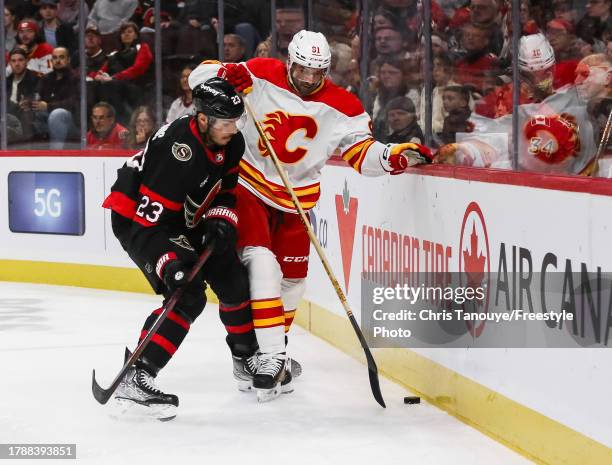 Travis Hamonic of the Ottawa Senators battles for the puck with Nazem Kadri of the Calgary Flames during the first period at Canadian Tire Centre on...