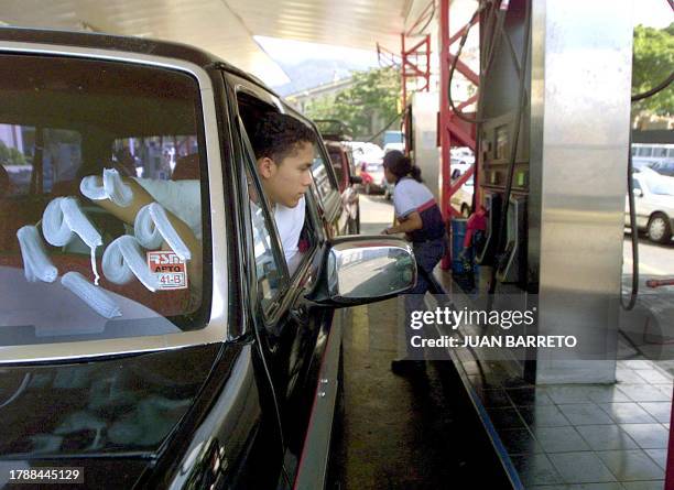 Motorist waits his turn at the gas station 22 January in Caracas, Venezuela. Oil prices went down in early trading 22 january on signs of progress in...