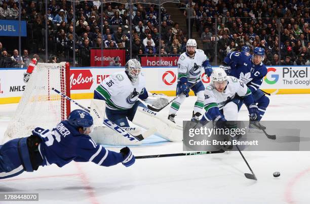 The Vancouver Canucks defend against Mitchell Marner and John Tavares of the Toronto Maple Leafs during the second period at Scotiabank Arena on...