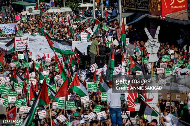 Amman, Jordan. Hundreds of demonstrators carry placards with the words 'America is the head of terrorism' and Palestinian flags during a solidarity...