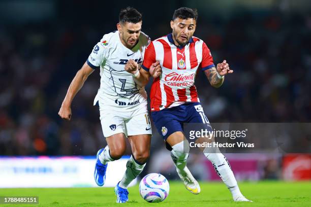 Alexis Vega of Chivas battles for possession with Eduardo Salvio of Pumas UNAM during the 17th round match between Pumas UNAM and Chivas as part of...