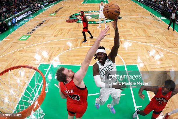 Jrue Holiday of the Boston Celtics takes a shot against Jakob Poeltl of the Toronto Raptors at TD Garden on November 11, 2023 in Boston,...