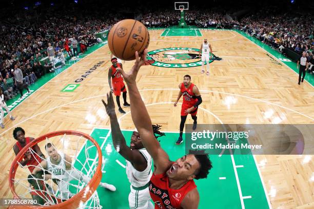 Scottie Barnes of the Toronto Raptors takes a shot over Jrue Holiday of the Boston Celtics at TD Garden on November 11, 2023 in Boston,...