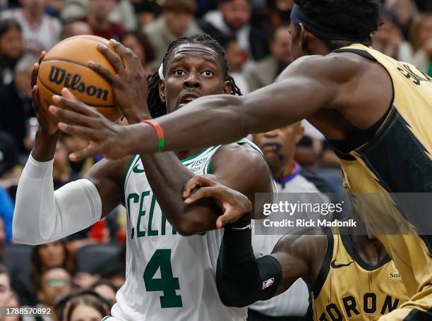 Boston Celtics guard Jrue Holiday weaves his way through Toronto Raptors guard Dennis Schroder and Toronto Raptors forward Pascal Siakam . Toronto...