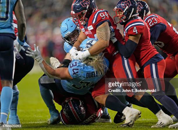 Mustafa Johnson and Tyrice Beverette of the Montreal Alouettes tackle AJ Ouellette of the Toronto Argonauts during the second half at BMO Field on...