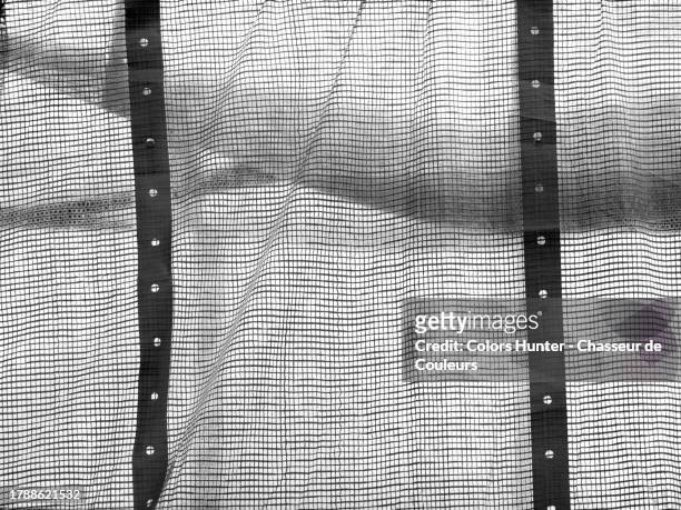 a white plastic sheeting reinforced with a grey metal mesh in paris, france - mesh fence stock pictures, royalty-free photos & images