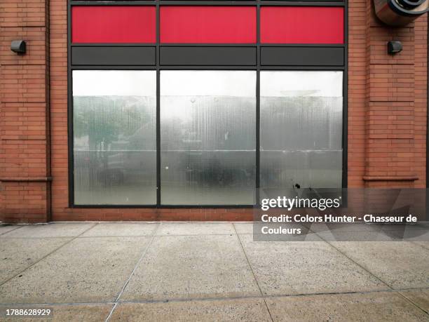 opaque and silver windows and brick wall of a closed store with cement sidewalk in manhattan, new york city, united states - shop window stock pictures, royalty-free photos & images