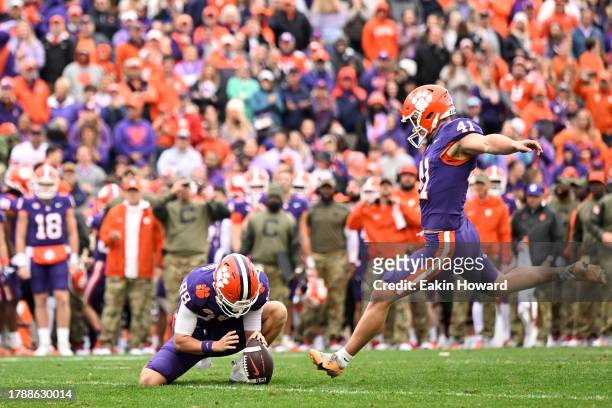 Jonathan Weitz of the Clemson Tigers kicks an extra point held by Clay Swinney of the Clemson Tigers against the Georgia Tech Yellow Jackets in the...