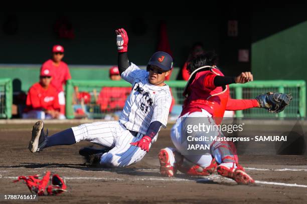 Infielder Kaito Kozono of Samurai Japan slides safely to score a run by the RBI single of Outfielder Chusei Mannami in the 6th inning during a...
