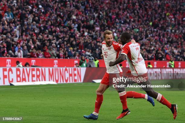 Harry Kane of Bayern Munich celebrates with teammate Dayot Upamecano after scoring the team's second goal during the Bundesliga match between FC...