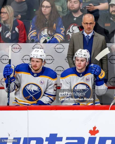 Head Coach Don Granato, Casey Mittelstadt and Zach Benson of the Buffalo Sabres look on from the bench during third period action against the...