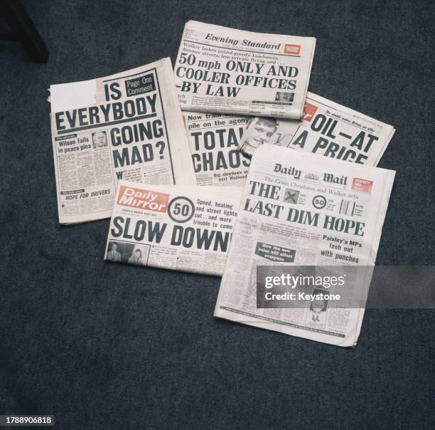 Group of British newspapers with headlines reading 'Is Everybody Going Mad?' , '50 mph Only and Cooler Offices - By Law' , 'Slow Down!' , 'Oil - At a...