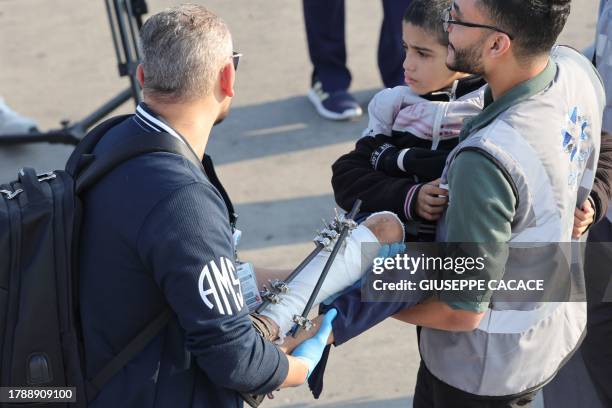 Volunteers transport a wounded Palestinian child off the plane upon their arrival in Abu Dhabi on November 18 after being evacuated from Gaza as part...