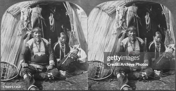 Stereoscopic image showing Native American Blackhead, a Ho-Chunk Chief, sitting with his family, including a child on a cradleboard, with the...