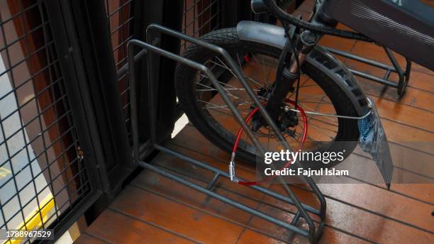 locked bicycle tires - bike lock stock pictures, royalty-free photos & images