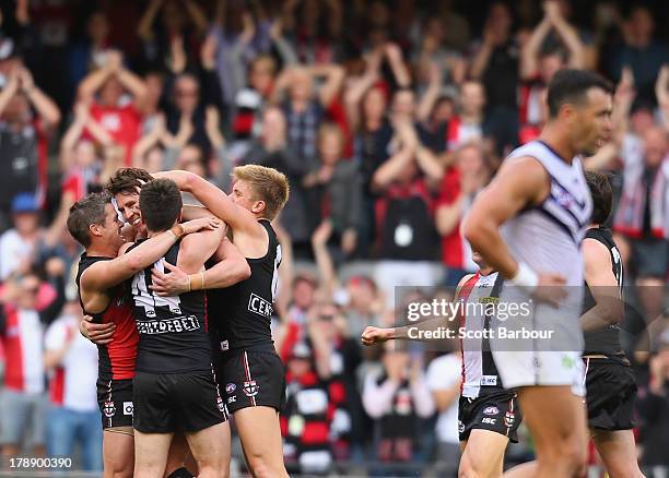 Justin Koschitzke of the Saints is congratulated by Stephen Milne and his teammates after kicking a goal changed to a point on review, during the...