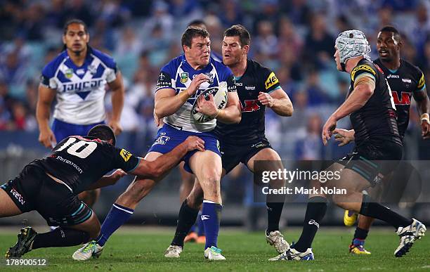 Josh Morris of the Bulldogs is tackled during the round 25 NRL match between the Canterbury Bulldogs and the Penrith Panthers at ANZ Stadium on...