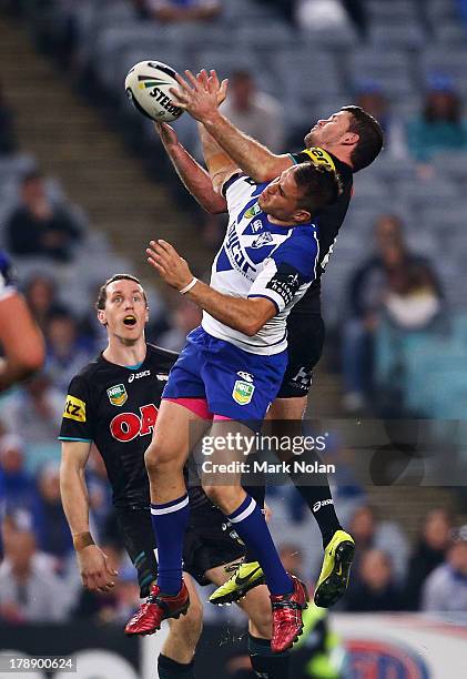 Josh Reynolds of the Bulldogs and Lachlan Coote of the Panthers contest a high ball during the round 25 NRL match between the Canterbury Bulldogs and...