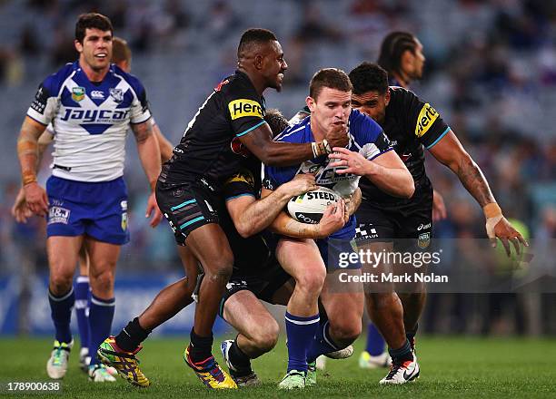 Tim Browne of the Bulldogs is tackled during the round 25 NRL match between the Canterbury Bulldogs and the Penrith Panthers at ANZ Stadium on August...