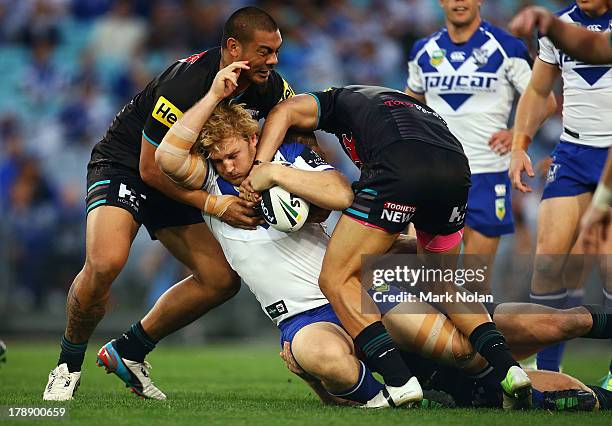 Aiden Tolman of the Bulldogs is tackled during the round 25 NRL match between the Canterbury Bulldogs and the Penrith Panthers at ANZ Stadium on...