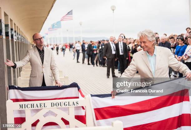 Michael Douglas and Steven Soderbergh pose next to the beach closet dedicated to them during a photocall on the Promenade des Planches for the movie...