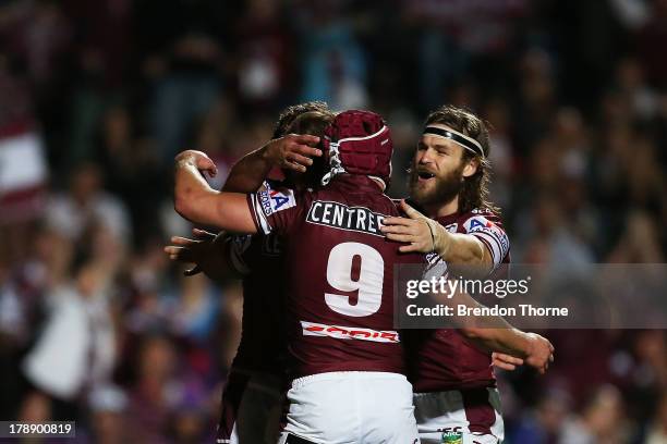 Brett Stewart of the Sea Eagles celebrates with team mates Matt Ballin and David Williams after scoring during the round 25 NRL match between the...