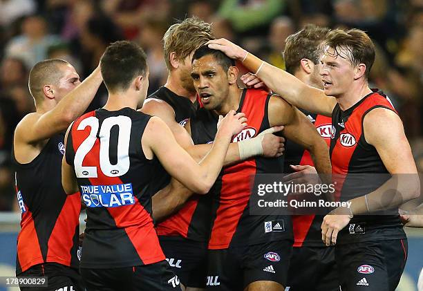 Nathan Lovett-Murray of the Bombers is congratulated by team mates after kicking a goal during the round 23 AFL match between the Essendon Bombers...