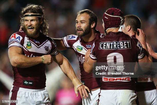 Brett Stewart of the Sea Eagles celebrates with team mates David Williams and Matt Ballin after scoring during the round 25 NRL match between the...