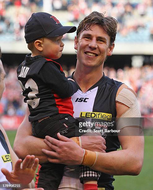 Justin Koschitzke of the Saints leaves the field with his son after the round 23 AFL match between the St Kilda Saints and the Fremantle Dockers at...