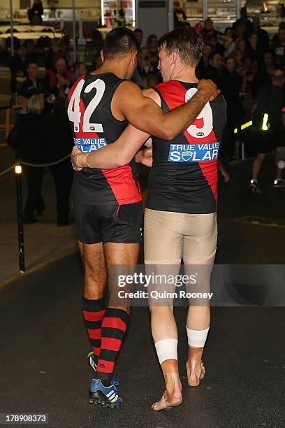 Nathan Lovett-Murray of the Bombers is consoled by Brendon Goddard after playing his last game during the round 23 AFL match between the Essendon...