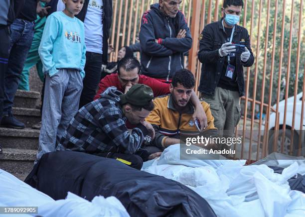 Palestinians mourn around the dead bodies in body bags at Nasser Hospital, where the bodies of those who lost their lives in Israeli attacks were...