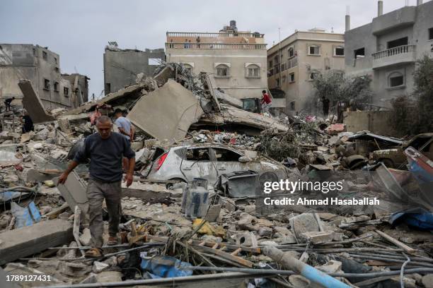 People search through buildings, destroyed during Israeli air strikes in the southern Gaza Strip on November 12, 2023 in Khan Yunis, Gaza. Heavy...