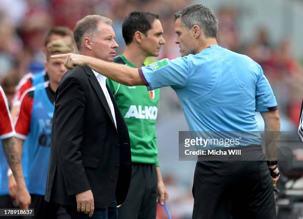 Referee Michael Weiner has words with CEO Stefan Reuter of Augsburg during the Bundesliga match between 1. FC Nuernberg and FC Augsburg at Grundig...